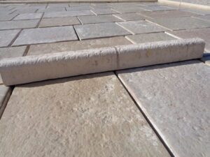 Bordure en pierre reconstituée pour jardin et voirie; basse et arrondie avec faux joint