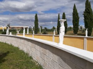 Mur de clôture revêtu des plaquettes de parement et des couvertines plates en pierre reconstituée